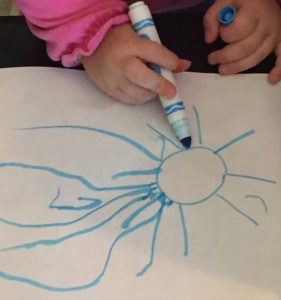 toddler practices drawing to prepare for letter strokes