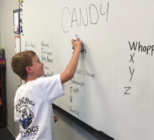 Students writing the names of candy A to Z