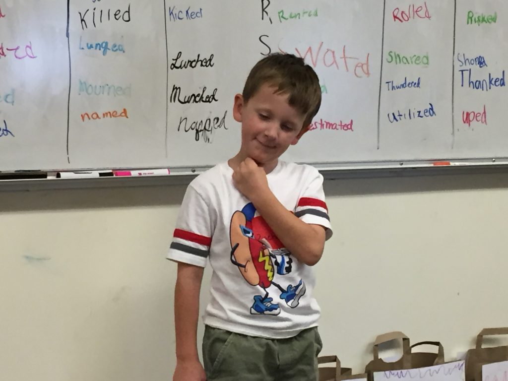 A child thinking in front of a group of students