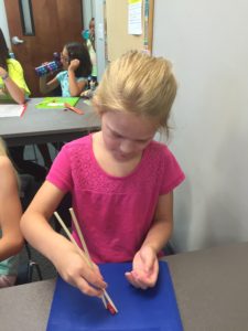 a student lifting hot tamales candy with chopsticks