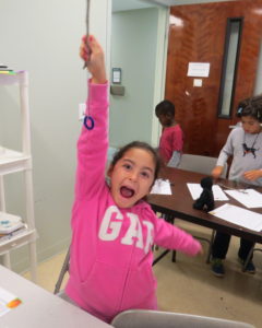 A student shows her completed ring toss.