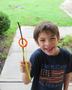 A child shows his completed ring toss.