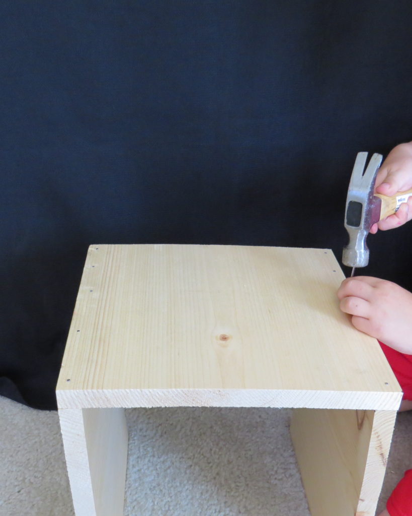 a child hammering in a nail