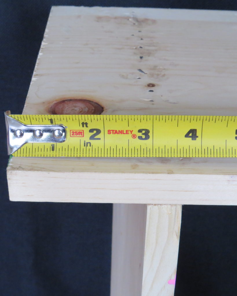 a tape measure measuring 3 inches from the bottom of the shelf