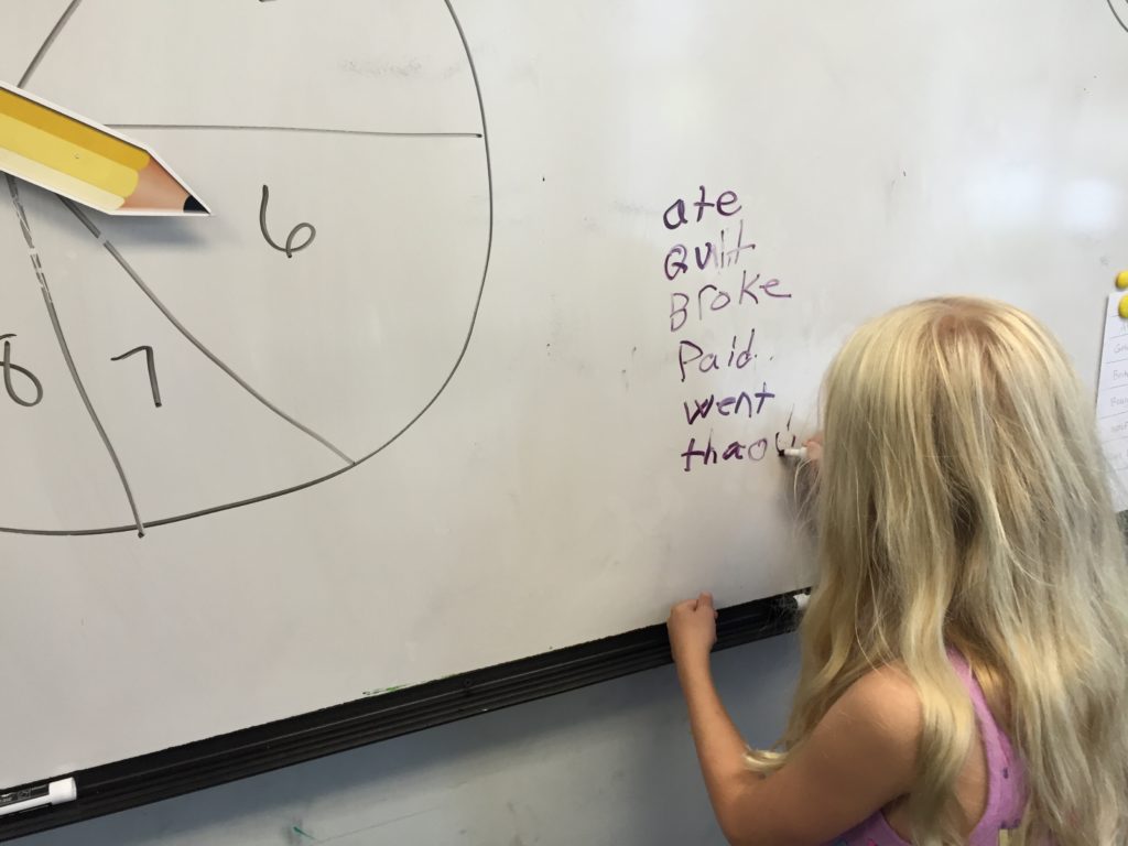 A child writes a list of Irregular past verbs